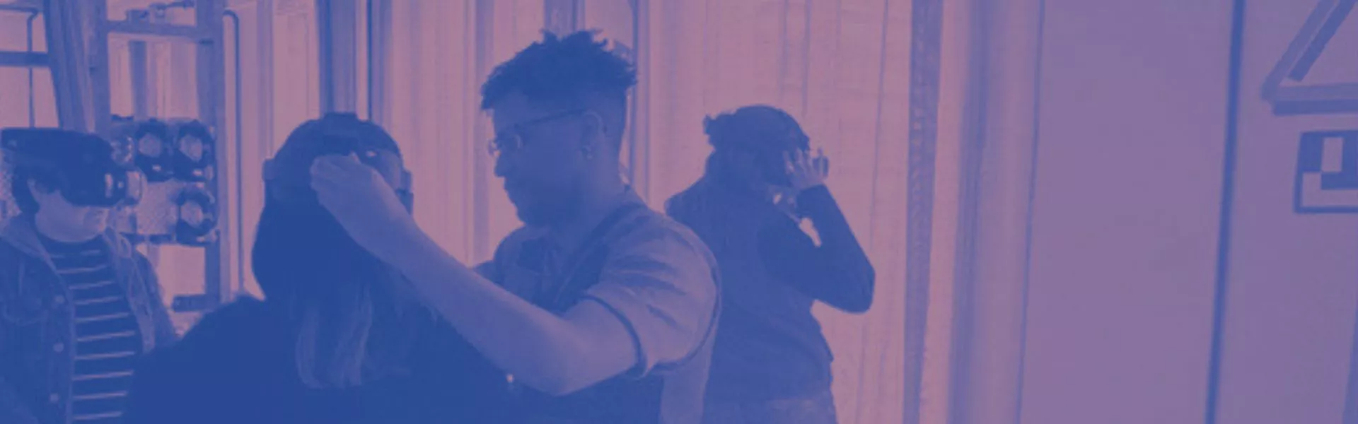 Une personne ajuste le casque VR d'une autre.